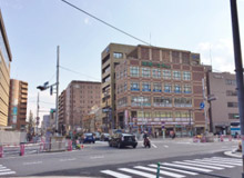 往第一土木大樓（1樓有Naka卯）過行人穿越道。建築後方可以看到飯店。